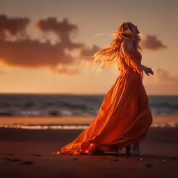 woman in orange dress on beach looking out to sea