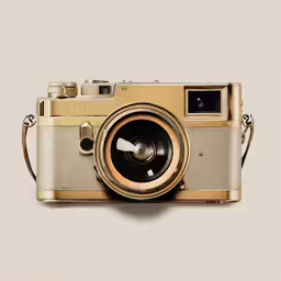 an old gold camera that is sitting on a table