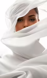 a woman in white is looking into the camera