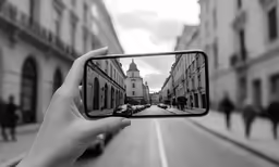 a woman taking a photo of a street with her phone