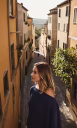 a woman is standing near a brick path
