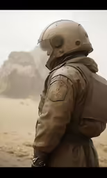 the pilot wearing an uniform is standing near mountains