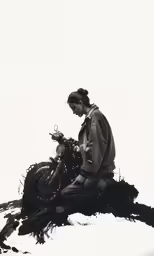 a woman sitting on top of a log and working on a cellphone