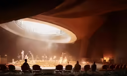 a person sitting in a chair looking at a stage