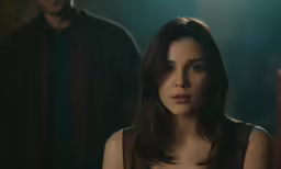 a beautiful young woman in black top standing in front of a man