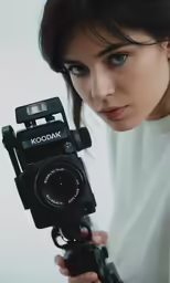 a girl holding a camera up to the camera