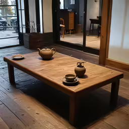 there are two empty bowls and a teapot sitting on a wooden table