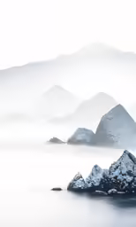 some snow covered mountains and water on a cloudy day