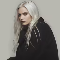 the blonde woman is sitting on a chair
