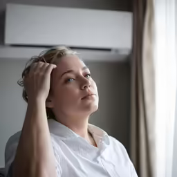 a woman is sitting looking into the distance