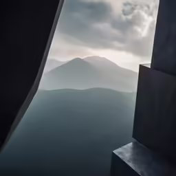 the view from a window at the top of a hill in front of the sky
