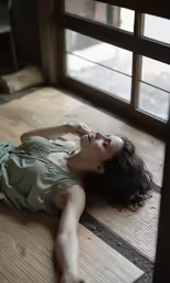 woman on floor near window staring upward