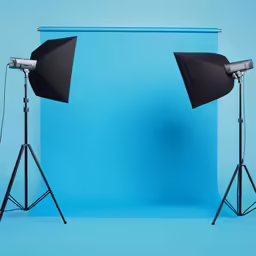 two light stands with lights next to them on blue backdrop