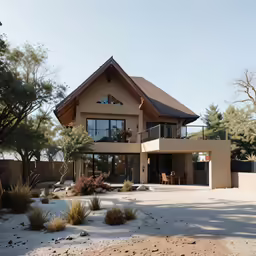 an adobe colored house with multiple levels, large windows, and a lot of sand outside