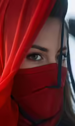 a woman wearing a red head scarf and eye makeup