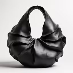 a black handbag with an intricate bow