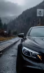 a car parked on a wet road with mountains in the background