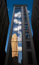 buildings reflecting their reflections in a large window