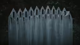 the dark gothic graveyard fence is lined with dark graves