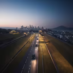 some cars driving along the highway with city in the background