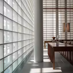 a white room with wooden benches and large glass panels on the wall
