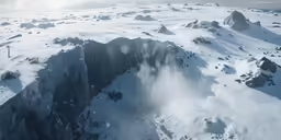 an aerial shot of mountains in the snow