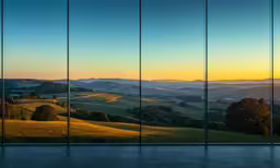 a wall with three glass walls with the view of hills