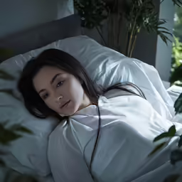 the woman is laying down under the covers in the bed