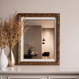 there is a vase with flowers and a mirror