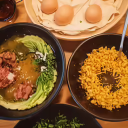 three bowls filled with different food sitting on top of a table