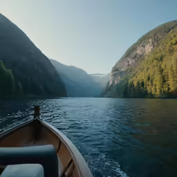 someone in the boat in a lake surrounded by mountains