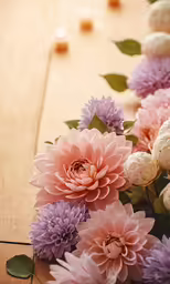 a bouquet of pink and purple flowers on top of a wooden table
