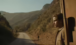 a man standing in the middle of a road with a dog standing behind him