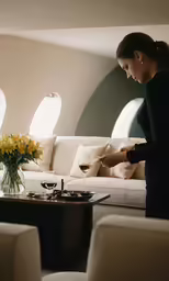 the woman stands before a table of glasses filled with wine