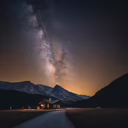 a night time sky with the milky over a road