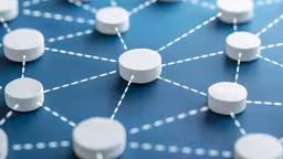 several small white pill caps on a blue surface,the electronic device has many small white buttons
