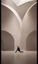 a man in black sits on his legs in a room that looks like he is sitting down