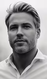 a man in a white shirt stares into the distance