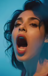 woman with open mouth and eyes on blue background