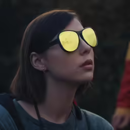 a woman wearing glasses has bright yellow light on her eyes