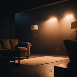 a dark living room with a sofa, chair and lamp