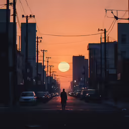 a person walking down a street in the sunset