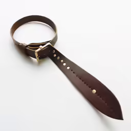 an old leather strap has gold buttons and is hanging from it
