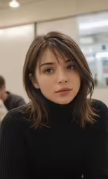 a woman is sitting down and looking at the camera