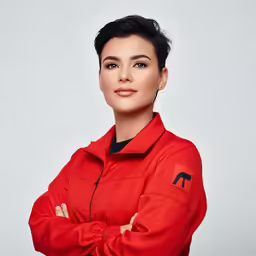 a woman wearing an orange jacket with her arms folded