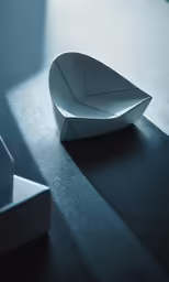 an empty paper boat laying on a black table