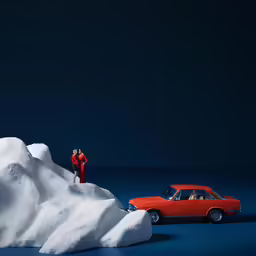 a red car parked on the snow, next to a stack of snow