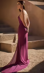 the back of a woman wearing a dress and posing outside