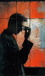 there is a man holding a cell phone up to his eye