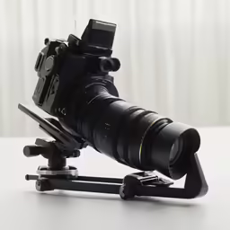 a camera sitting on a tripod on a white table